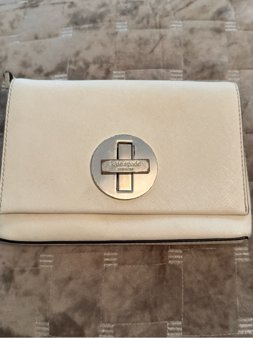kate spade cream crossbody with gold circular turn-lock